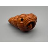 A hand carved Japanese netsuke of a toad with a shell with another baby toad st on top. Both