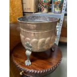 A Large antique copper urn planter.Designed with lion head handles and claw pedestal feet. [
