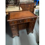 A reproduction ladies writing desk with brown leather top. Designed with drawers don either sides