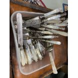 A Tub containing a quantity of mother of pearl handled cutlery.