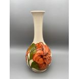 A Vintage Moorcroft vase detailing a tubelined Hibiscus flower design. Impressed to the base and