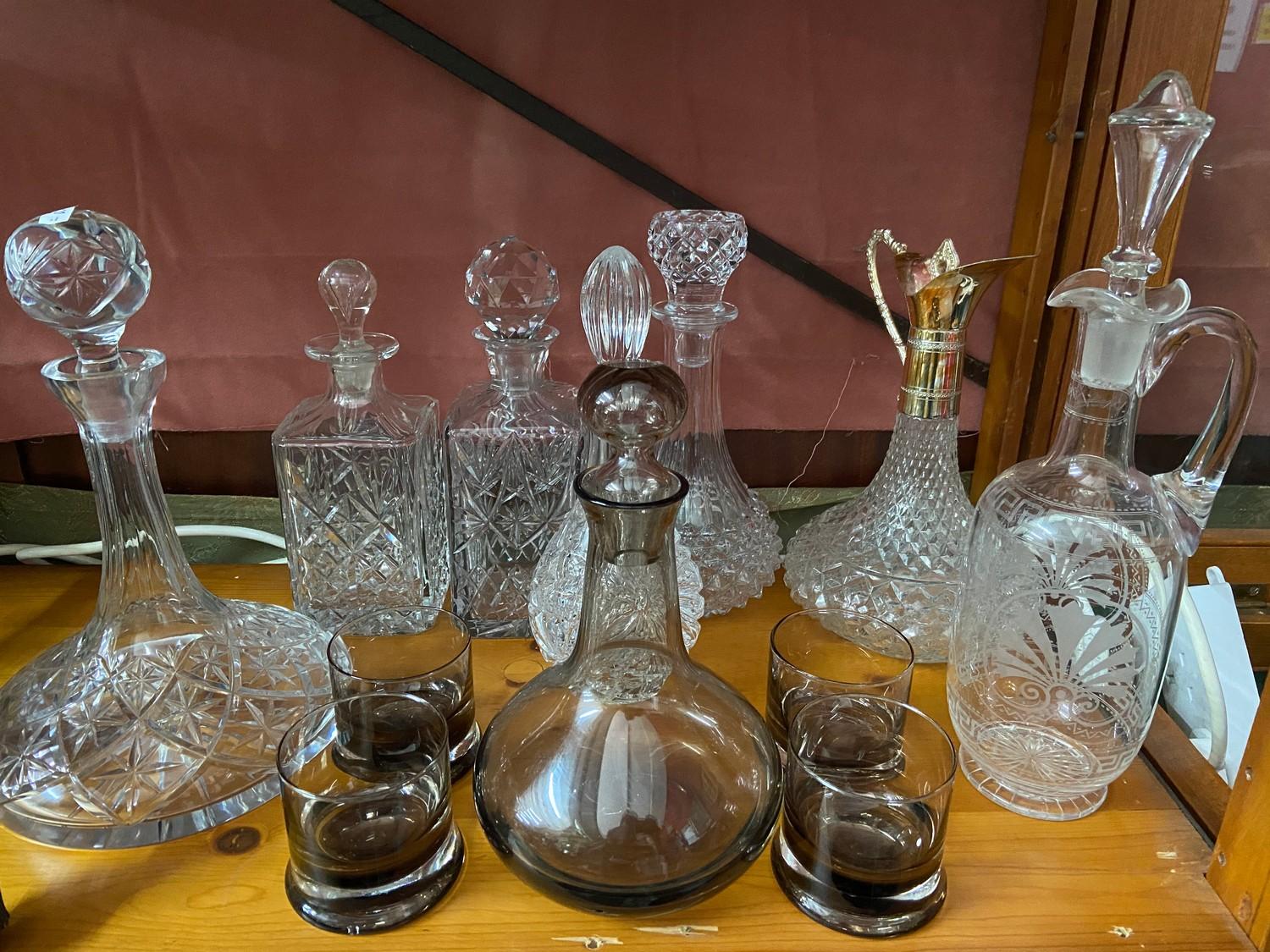 A Lot of vintage and antique cut crystal and glass decanters which includes smoked glass whisky