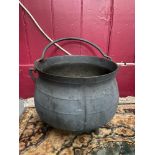 A Large antique cast iron three foot cauldron with swing handle. [30cm height, 37cm diameter]
