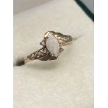 A Ladies 9ct gold ring set with a single opal stone off set by two single diamonds. Ring size 0.