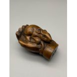 A Japanese hand carved netsuke of a mouse within a hand. Signed by the artist. Mouse is detailed