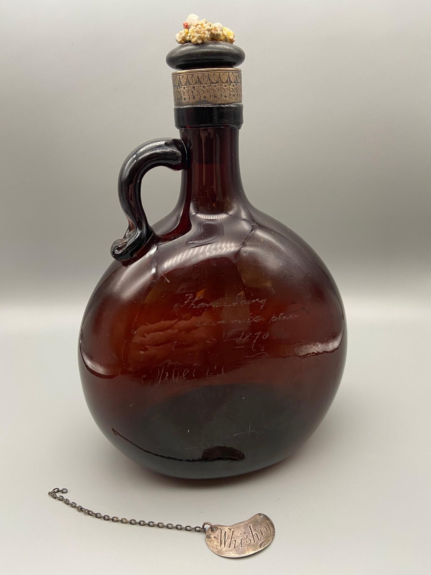 A Victorian brown glass whisky flagon designed with a possible silver collar, Also comes with a