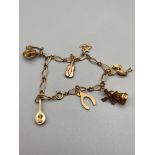 Antique 9ct gold charm bracelet designed with 6 9ct gold charms and one 14ct gold charm. [11.50