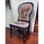 A Victorian balloon back chair designed with a needlework tapestry back rest and seat area.