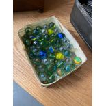 A Box containing a quantity of vintage marbles.
