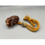 A Meiji period hand carved Japanese netsuke of an Ox laying down, Design with black bead eyes,