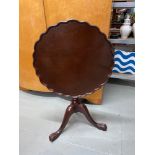 A Reproduction flip top side table. Designed with pie crust edge.