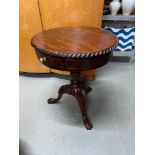 A Reproduction hard wood barrel top table with two under drawers. 73x60x60cm]