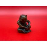 A Japanese hand carved netsuke of an okimono monster sitting. Signed by the artist.
