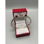 A Ladies 18ct white gold bangle set with various red stones. Marked 750 and tested [4.5x5.5cm inside