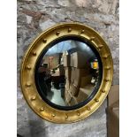 A Regancy convex mirror finished with a gold leaf frame