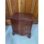 A Reproduction bow front three drawer bedside chest.