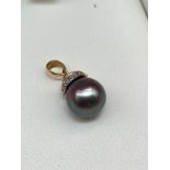 An 18ct gold, diamond and large black pearl pendant. [pearl 0.8cm diameter] [2.62grams]