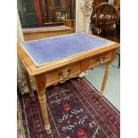 A Victorian two drawer writing desk designed with turned leg supports and purple velvet writing