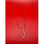 A 9ct gold necklace with a 9ct gold hockey stick pendant. [9.87grams] [Chain 46cm length]