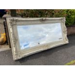 A Large reproduction ornate framed wall mirror. Mirror is designed with a bevel edge.