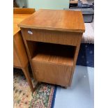 A Mid century teak pedestal bedside cabinet, designed with single drawer, shelf and single door