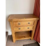 A Contemporary solid light oak two drawer console table.