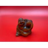 A Japanese hand carved netsuke of a laughing buddha and child. Signed by the artist