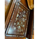 An oriental hardwood serving tray designed with mother of pearl inlays.