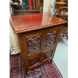 An early 1900's four door storage cabinet. Designed with carved panels and Regency style handles.