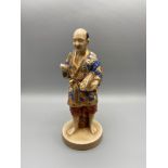 An early 20th century Japanese porcelain man figure. Hand painted with gilt trims and stamped
