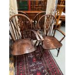 A Lot of two carver chairs designed with a spindle and cartwheel back area.