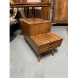 A Mid century teak slipper box designed on pedestal legs and showing two single drawers