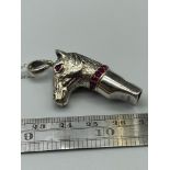 A Sterling silver horse head whistle with ruby eyes on a silver chain.