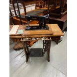A Vintage Singer sewing machine designed with pedal action and built in cabinet with various
