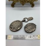 A Victorian silver locket detailed with ornate initials and pendant loop, together with a Birmingham
