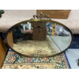 Antique heavy oval metal framed mirror.
