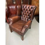 Antique brown Chesterfield gullwing arm chair.