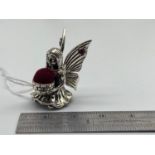 A Sterling silver fairy pin cushion designed with two ruby stones.