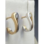 A Pair of two tone 9ct gold earrings designed with two single diamonds.