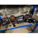 A Shelf containing a quantity of vintage cameras and equipement which includes Alpa Reflex 11e