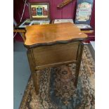 A vintage light oak sewing /backgammon table. Designed with a lift up and swivel top. [62cm height]