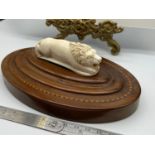 A Late Victorian ivory carved lion sculpture sat upon an inlaid wooden oval base. [Base 16cm length]