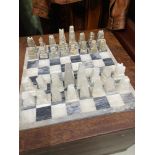 Heavy marble chess board together with hand carved hard stone chess pieces.