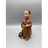 An early 20th century Chinese nodding boy figure, possible made from clay. Hand painted robe and