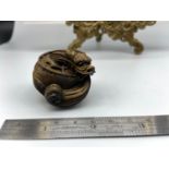 A Japanese netsuke of a curled up dragon, designed with black bead eyes.