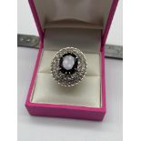A Lovely example of a ladies 18ct gold ring set with a large single garnet surrounded by 0.70ct
