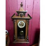 Antique wall clock designed with a brass art nouveau floral face and enamel trim showing roman