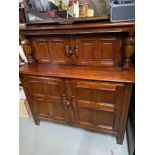 An Ercol style court cabinet. Designed with sliding locks and consists of four doors and fitted