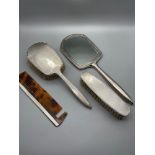 A Four piece Birmingham silver dressing table set. Includes Mirror, two brushes and comb. Produced