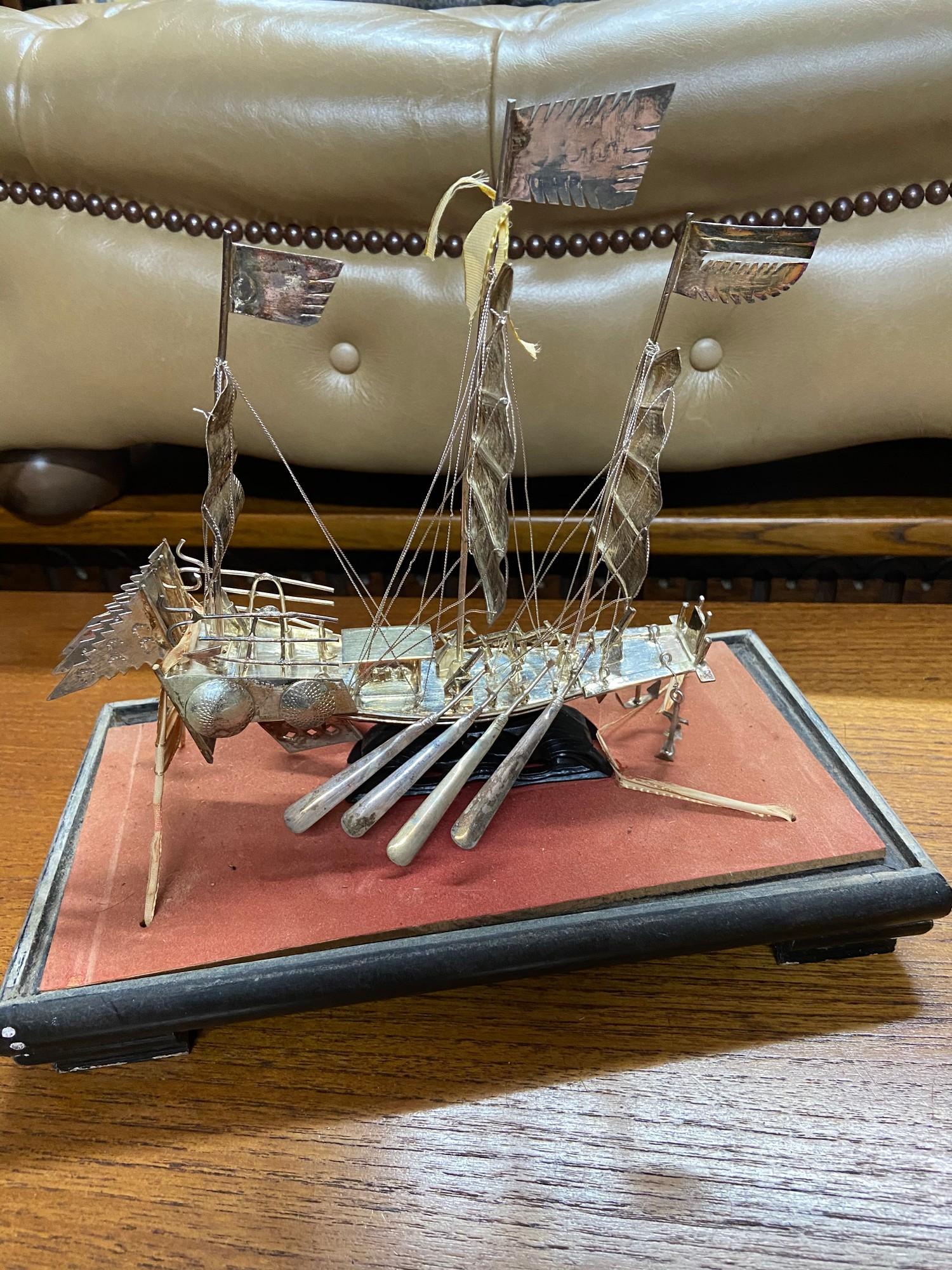 A Silver Chinese Junk boat model within a glass display. [Ship model stands 20cm in height]